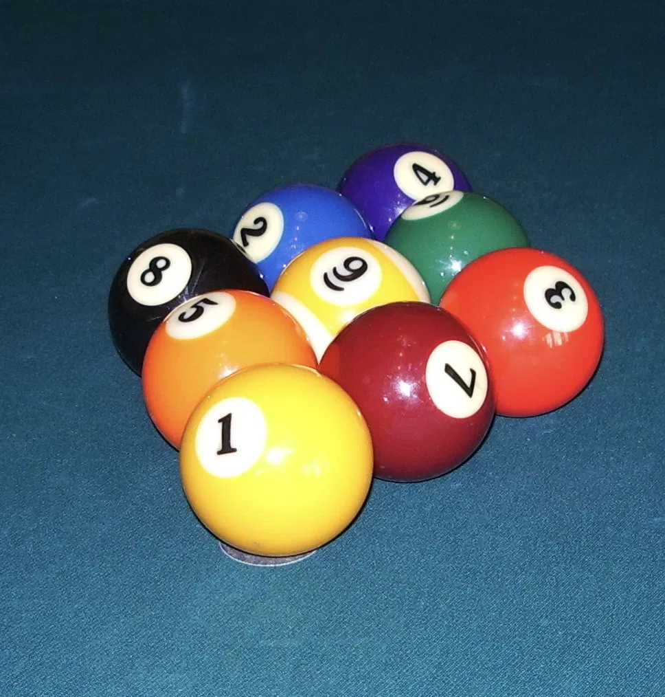 A nine-ball rack set on blue pool table cloth
