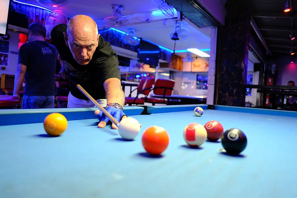 A player lines up a shot under arena lights during tournament play